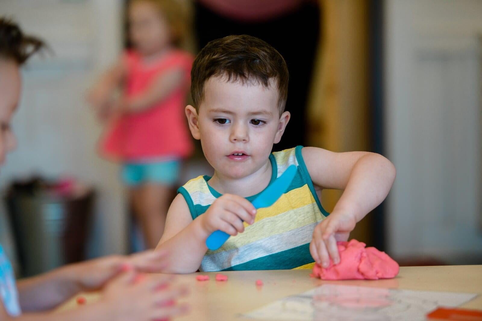Boy playing with playdough in a classroom